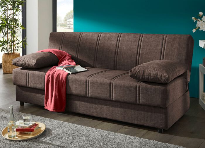 Frei im Raum aufstellbares Schlafsofa mit Dekokissen und Bettkasten 