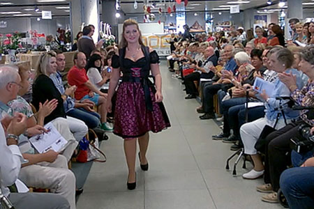 Modenschau im BADER-Direktkauf: Ein Model läuft über den Laufsteg zwischen zwei Reihen klatschender Zuschauer.